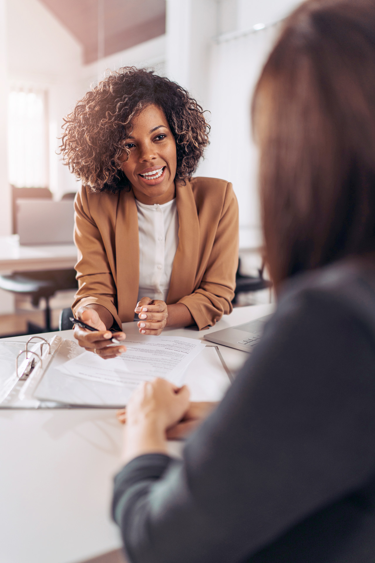 African American female consultant smiles as she discusses Revenue Cycle Management with the practice owner